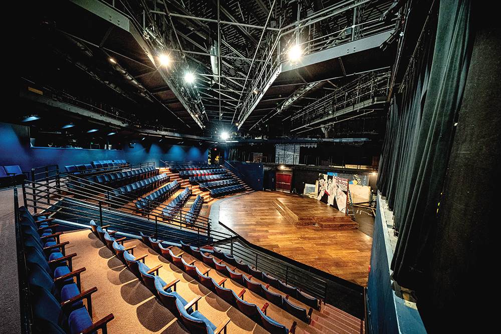 A wide-angle photograph of the Strosacker Theatre on the campus of Alma College showing the seats and the stage.