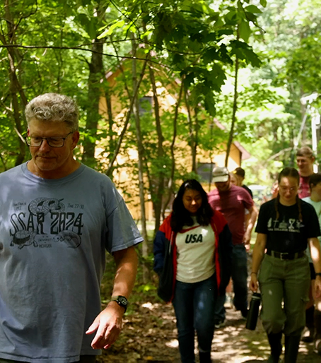 Professors and students walking on a trail at the Alma College Ecological Station.